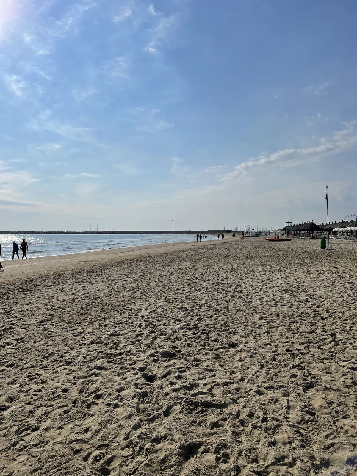 A broad sandy beach and calm shoreline in daylight
