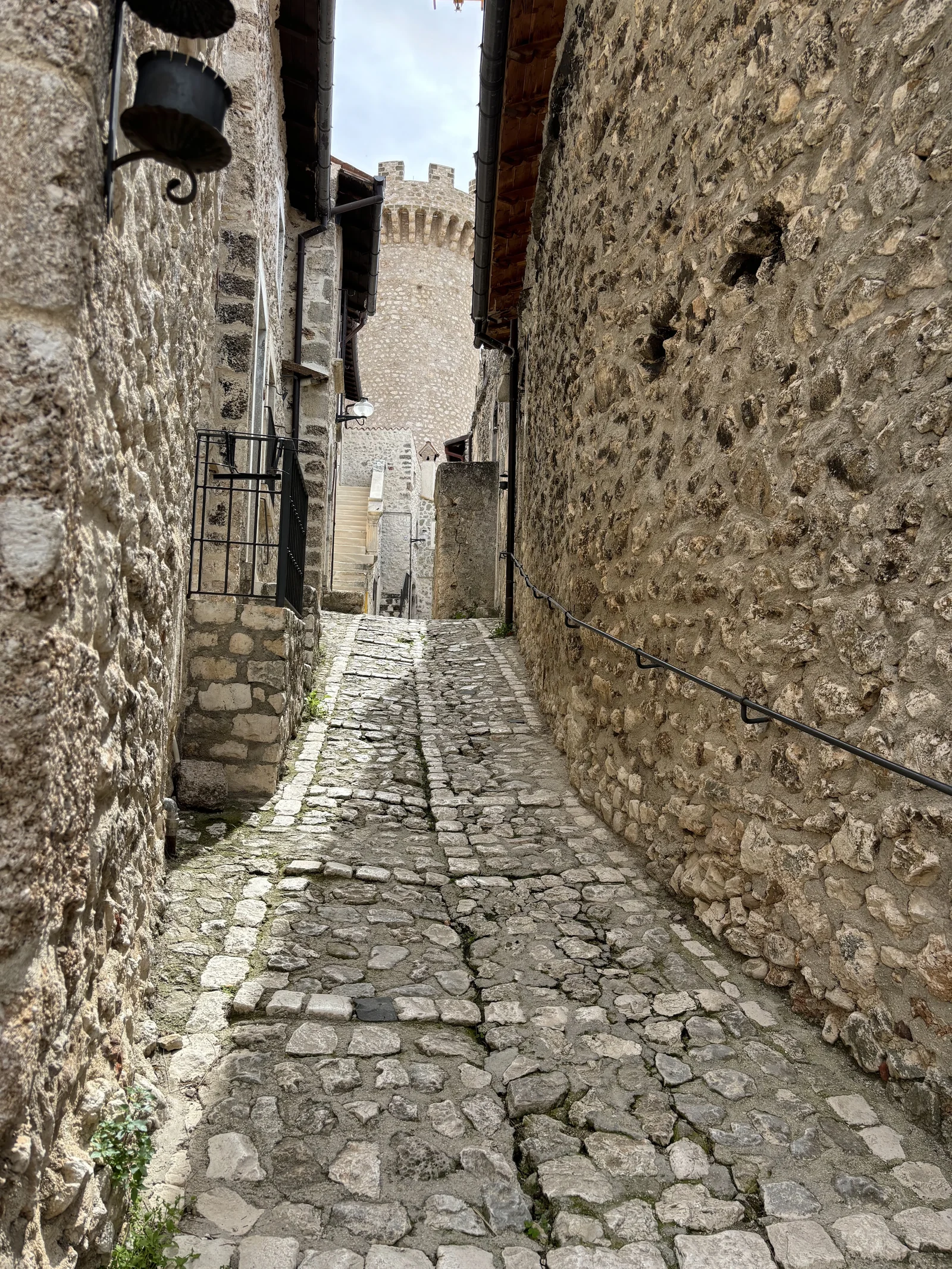 A narrow cobbled passage between stone buildings